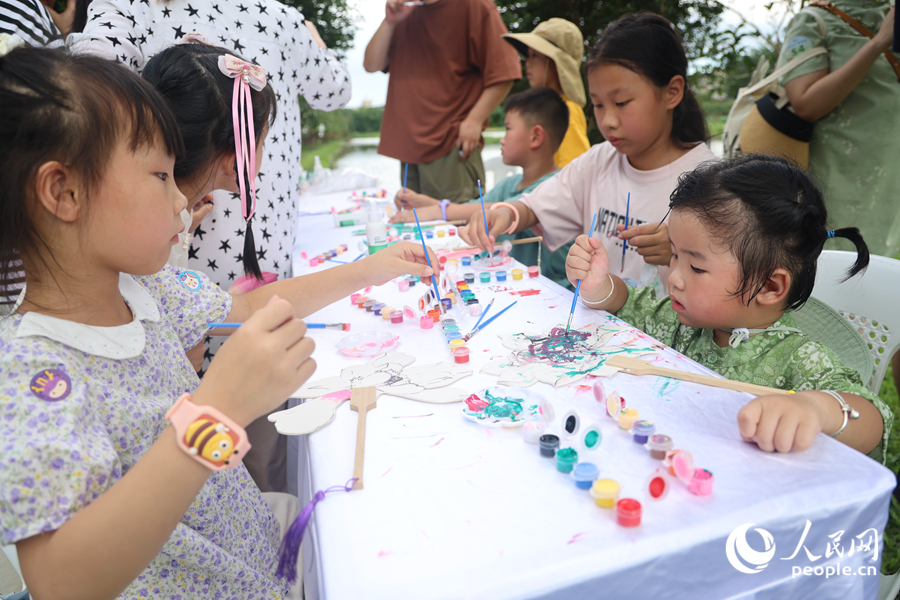 孩子们在莲香扇面上绘画。人民网记者 陈博摄