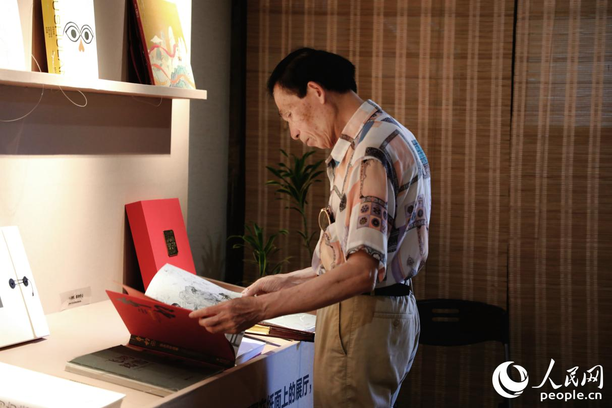 一位老人翻阅展出书籍。人民网 李唯一摄