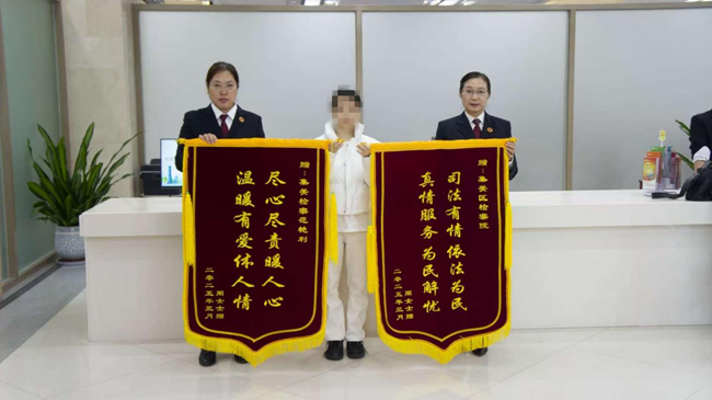 周女士贈錦旗向檢察官表達謝意。集美檢察供圖