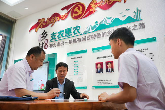 农行工作人员在“惠农服务旗舰店”暨“李文慰劳模工作室”向农户介绍农户贷款