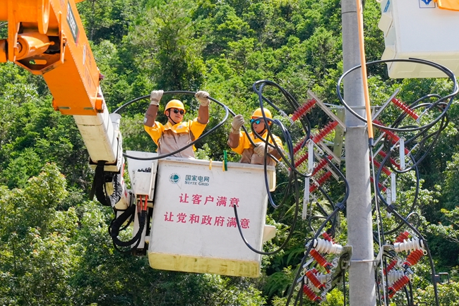 電力工人正在檢修線路設備。黃小芬攝