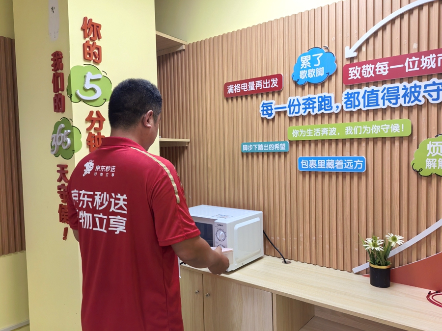 一名快递员在“新邻驿站”内歇息、充电。思明区委社会工作部供图