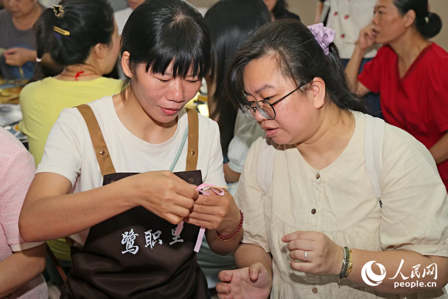 工作人员向居民讲解架子结编织技巧。人民网记者 陈博摄