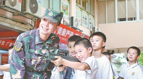 老兵在指导小营员进行射击体验。