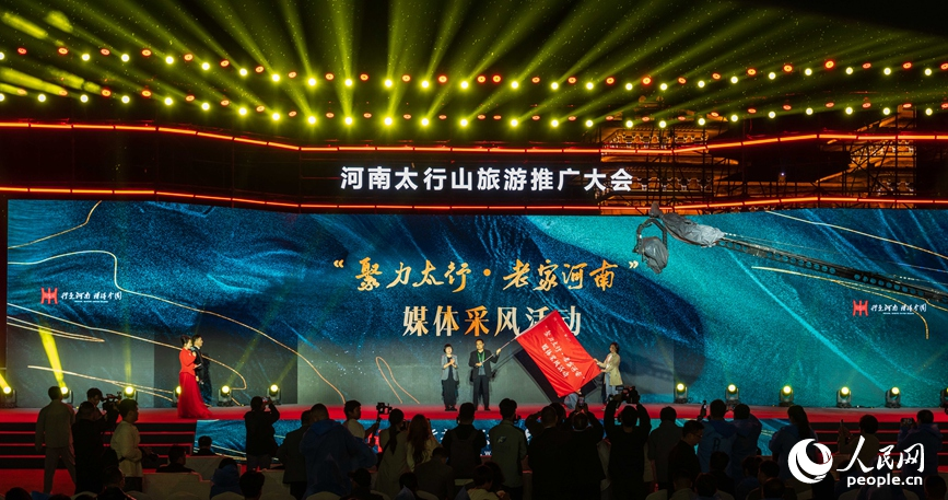 人民网党委委员、监事会主席唐维红为媒体采风团授旗。人民网记者 霍亚平摄