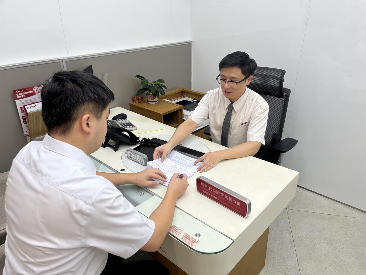 招商银行泉州分行顺利办结首笔个人住房公积金贷款，市民吴先生（左）成为这项服务的第一位体验者。