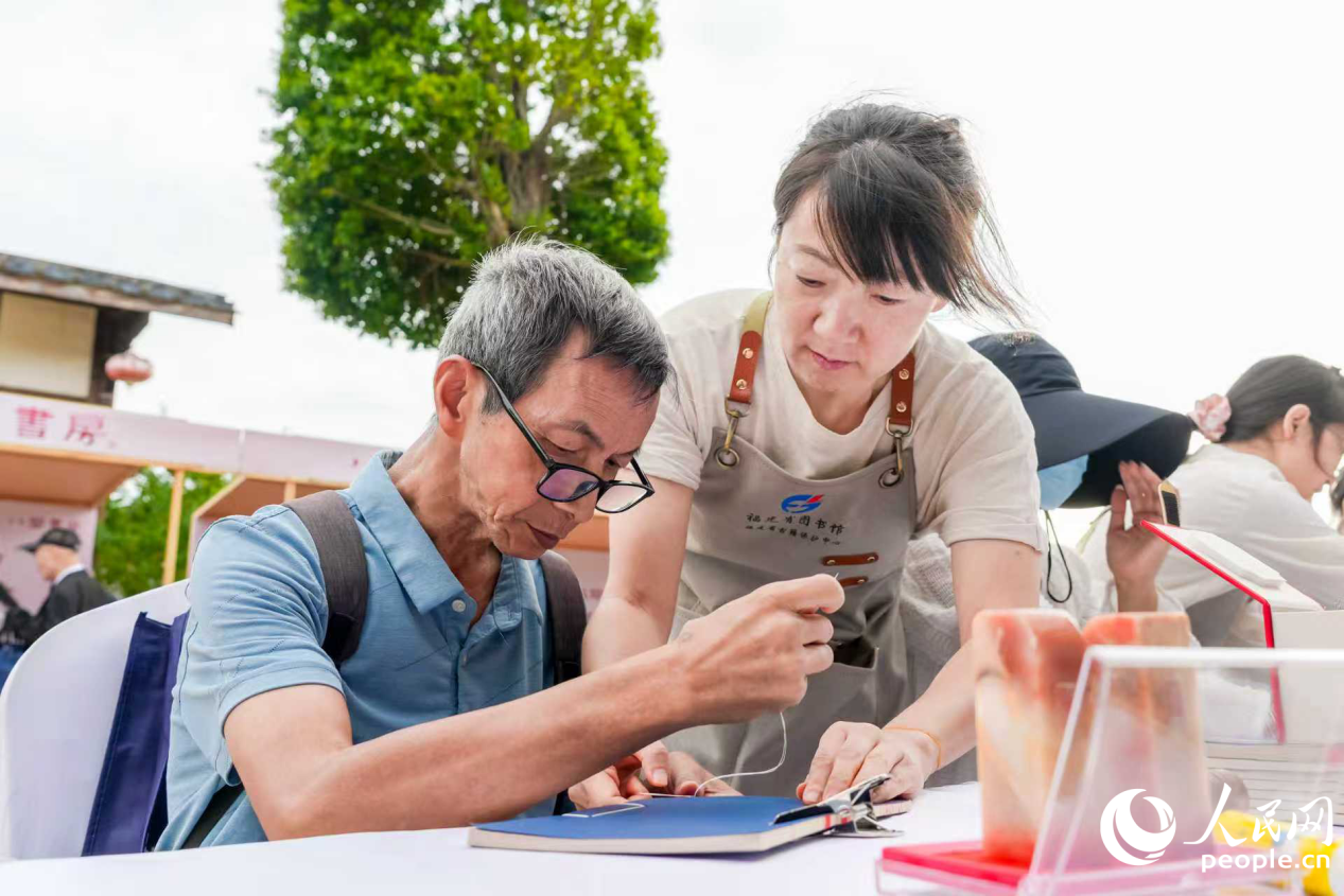市民在“八閩書房”書香市集體驗線裝書裝幀。人民網攝