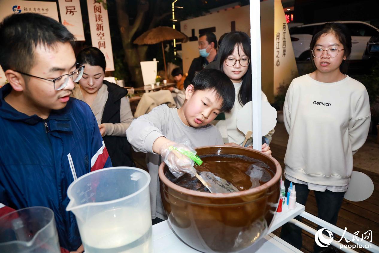 读者们现场体验漆扇制作，留念这段茶香漫溢的时光。人民网记者 陈永整摄