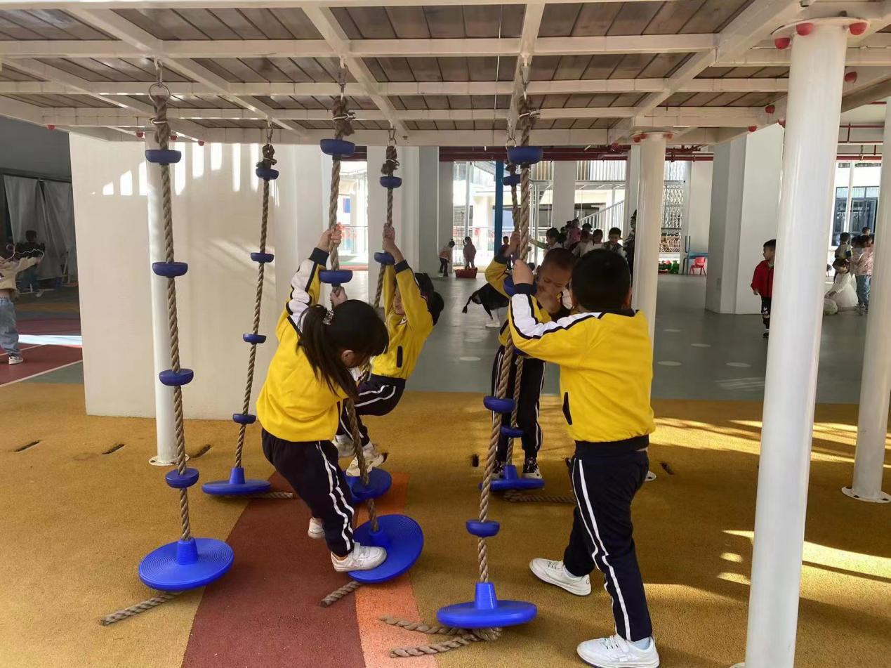 王桥分园的孩子来到总园，在体育器械上运动。明溪县实验幼儿园供图