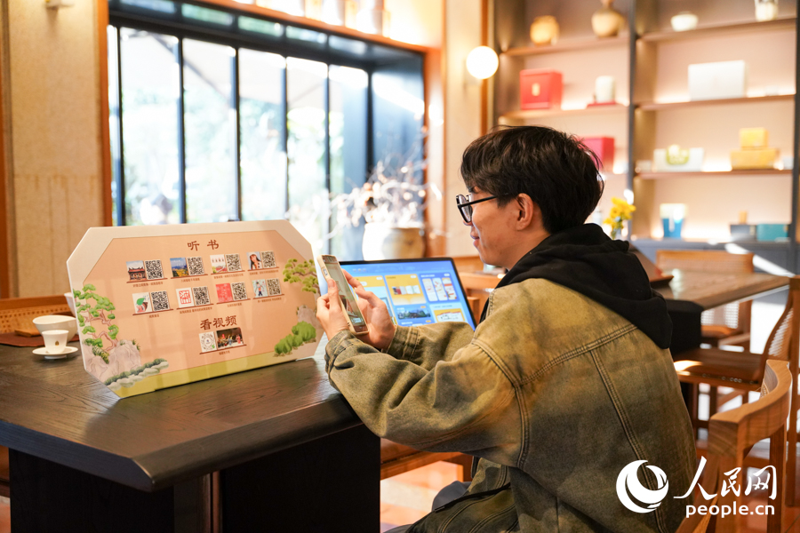 读者使用手机扫码，便可一键解锁福建艺术文献宝库。实习生 郑舒尘摄