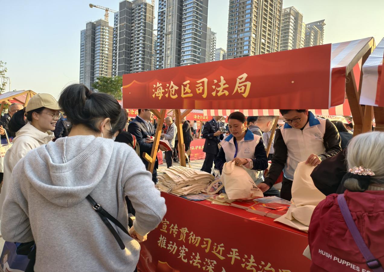 司法局摊位，“蒲公英”普法志愿者分发宣传材料。海沧区司法局供图