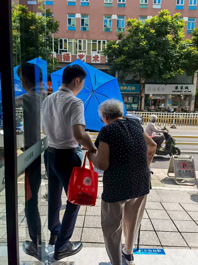 工作人员搀扶行动不便的老人