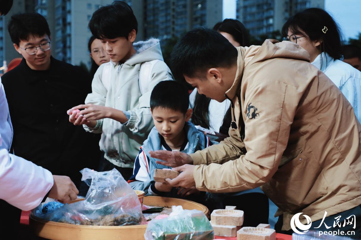 现场观众体验莆田特色小吃红团制作。人民网记者 李唯一摄