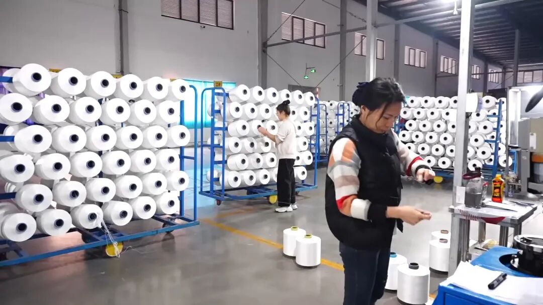 纺织生产车间内，工人正在操作巡检。