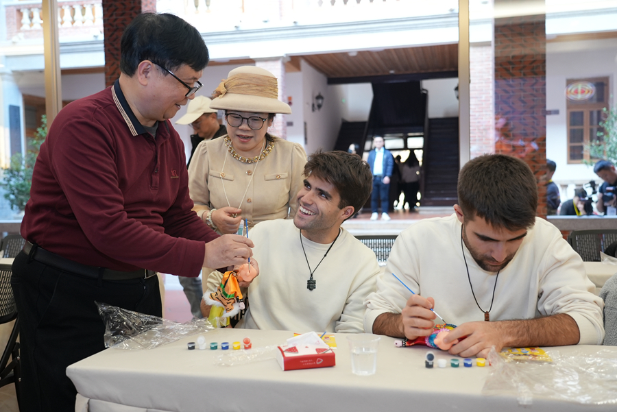 非遗代表性传承人现场亲授技艺，来宾执笔为木偶赋彩。卢臻摄