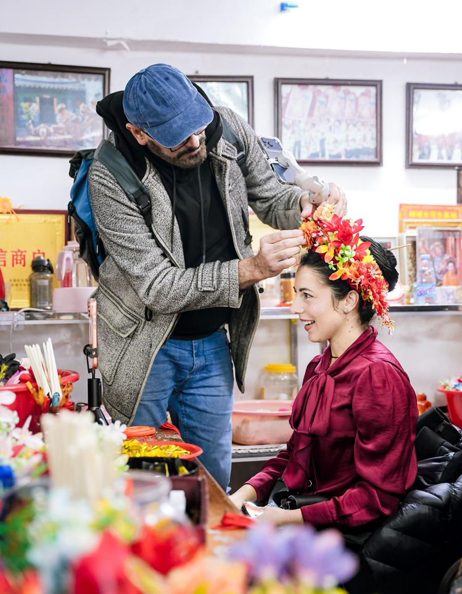 來自歐洲的旅游達人在梳妝台前佩戴“簪花圍”,感受獨特習俗。盧臻攝