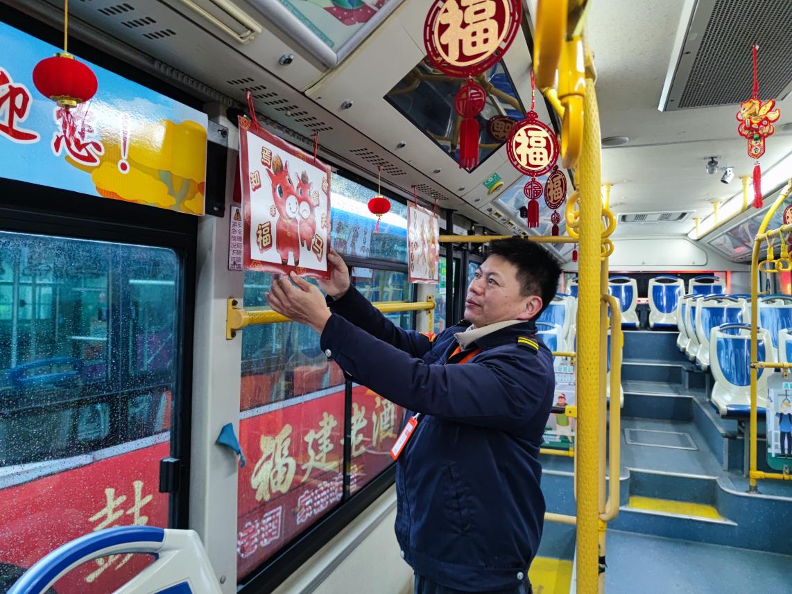 工作人员为公交车装点新春装饰