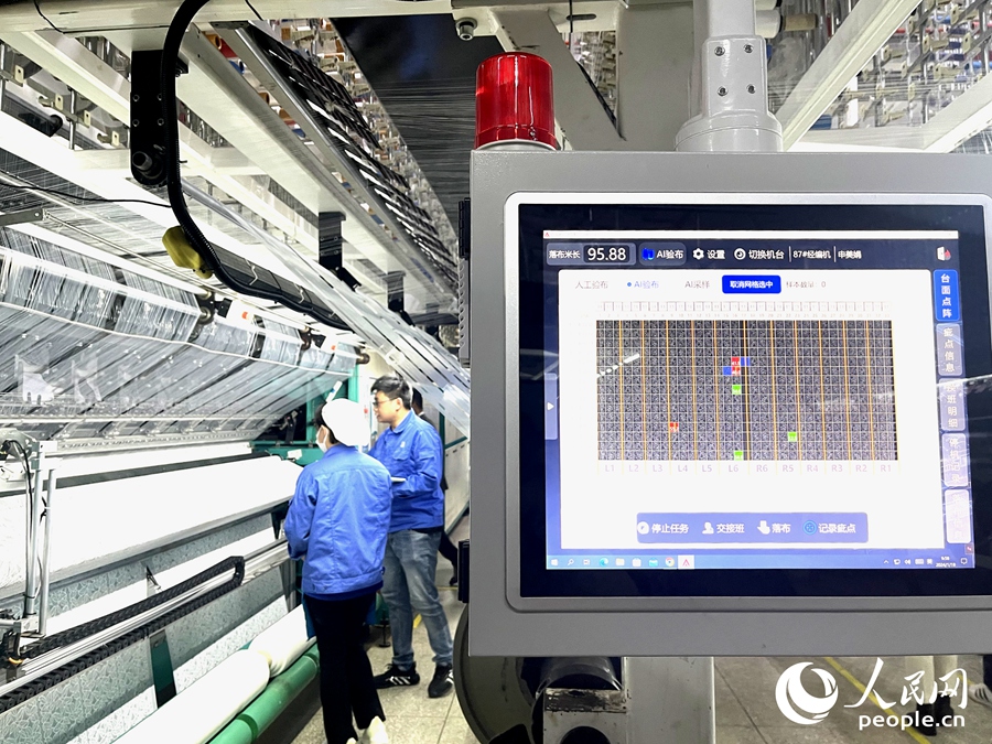 AI智能检测系统正在检测东龙针纺坯布上的瑕疵。人民网记者 陈蓝燕摄