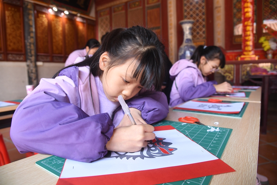 在泉港区后龙镇涂坑古民居刘氏宗祠内，孩子们正在进行年画剪纸体验