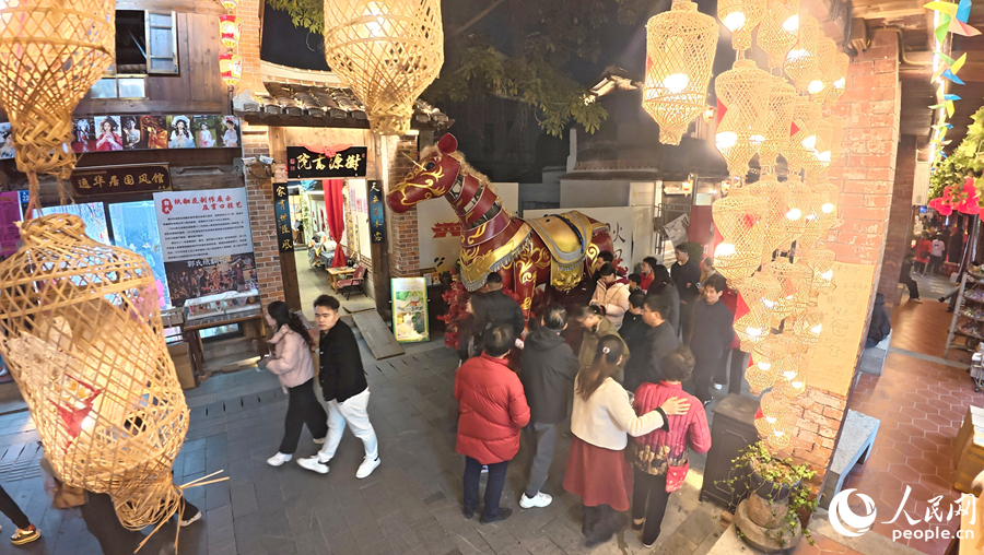 古街上竹灯映衬下的红色“骏马”，将马年新春氛围感拉满。人民网记者 李昌乾摄