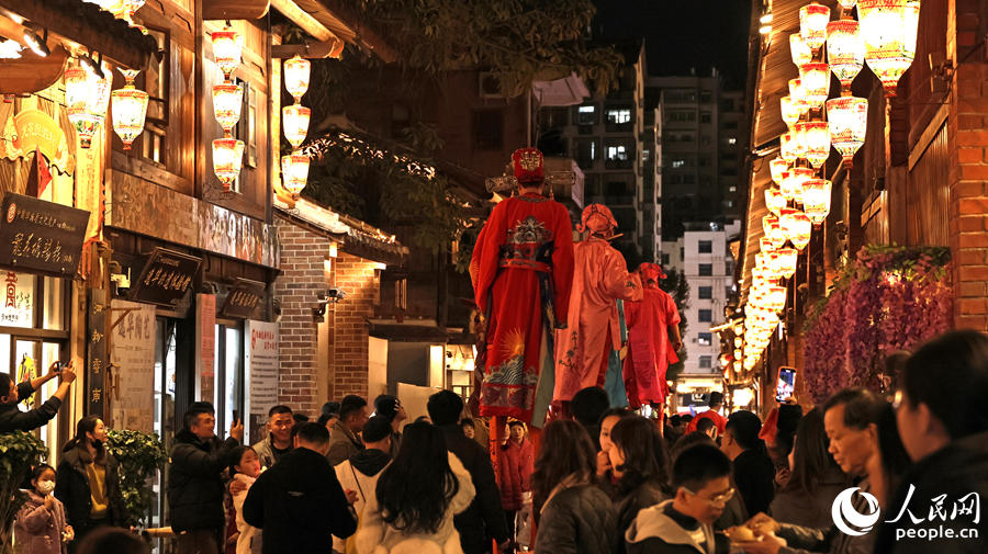 身着状元服饰的高跷艺人巡游古街，游客争相拍照。人民网记者 李昌乾摄