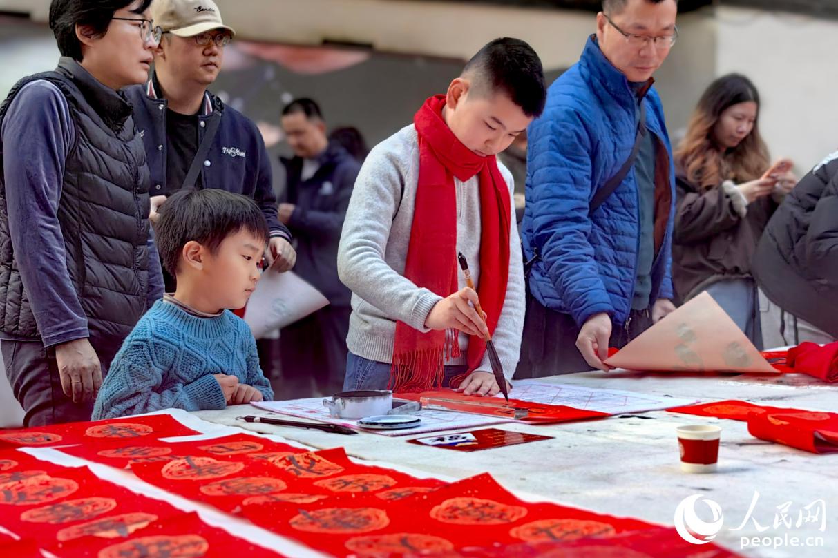 小朋友一笔一画专注书写，引人围观。人民网记者 叶青卿摄
