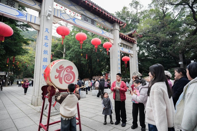 游客敲响“迎春鼓”