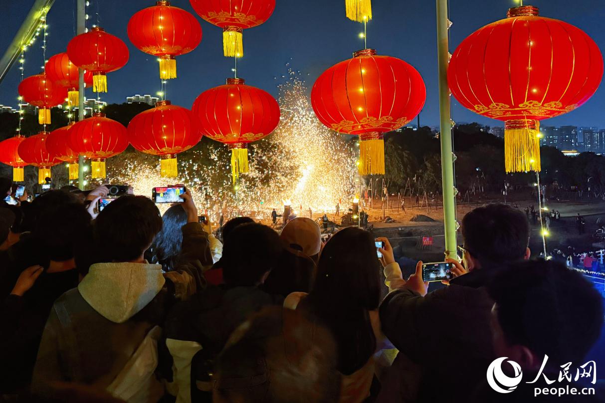 市民游客拿起手机拍摄记录打铁花。人民网记者 李唯一摄