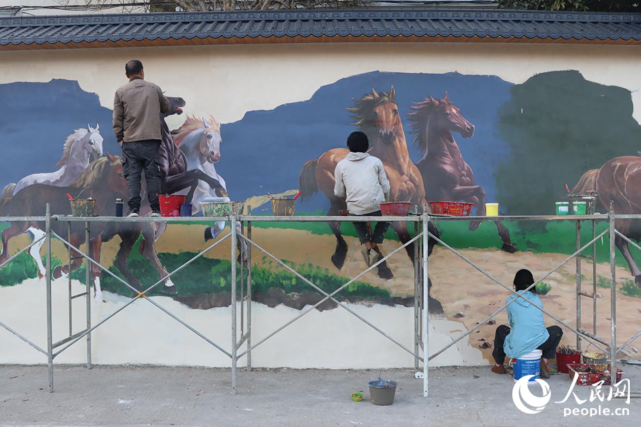 应村民提议，双坑村邀请青年艺术家绘制墙绘。人民网 林铭贤摄