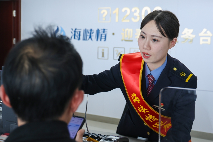 三明北站海峽情·迎春花服務台工作人員正在引導旅客進站候車。張海根攝