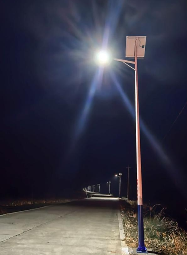 入夜，路灯次第点亮，村道被暖光铺满