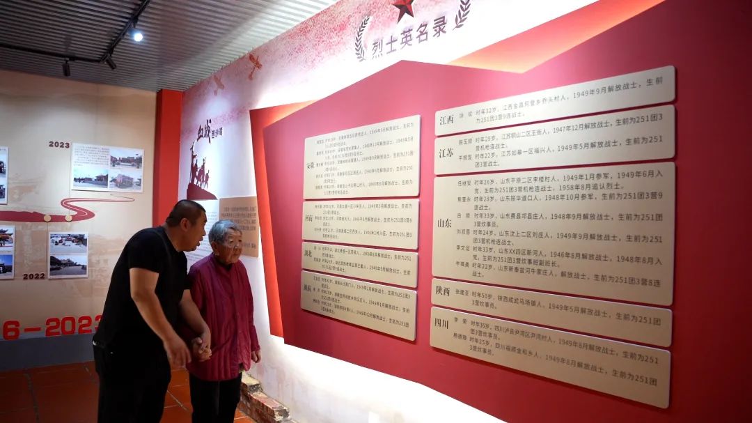 烈士纪念馆登记了解放军庙供奉的27名烈士名录，图为张凯陪奶奶重温烈士名单。杜志鑫摄