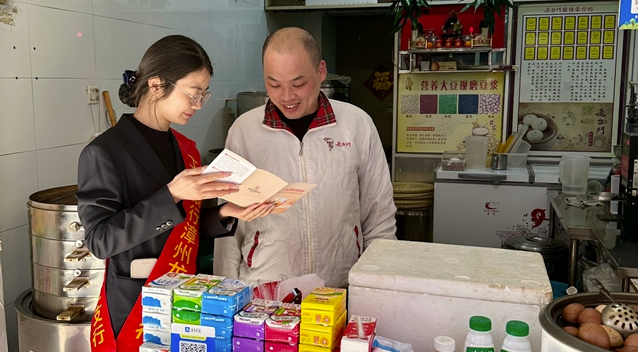 工作人员走访商户，讲解相关知识