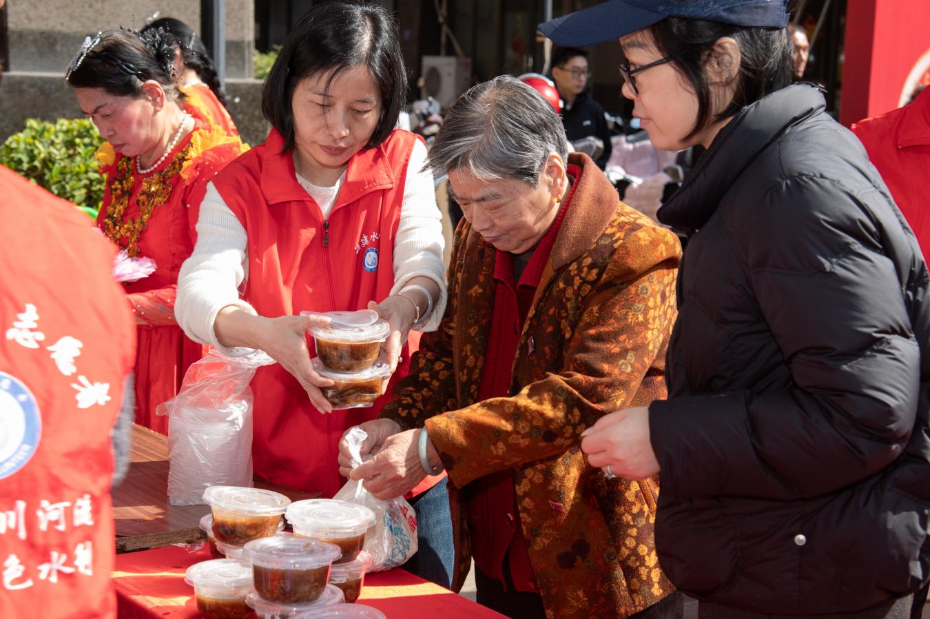 省水利厅在职党员志愿者为社区老人送上热气腾腾的拗九粥。陈美蓉摄
