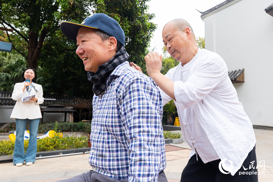 现场老人上台参与气功拍打互动,疏通经络、活络筋骨。实习生 李雨泽摄