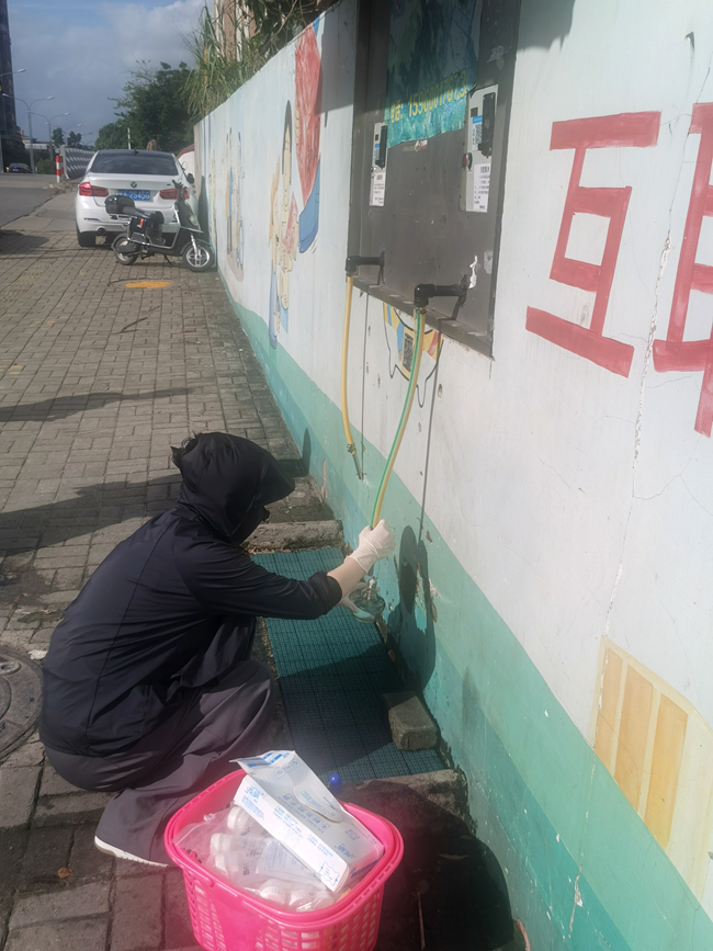 疾控中心工作人员现场抽取水样