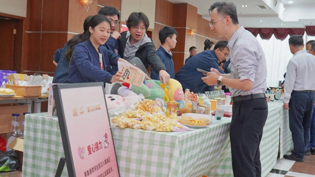 職工在義賣攤位前選購愛心商品