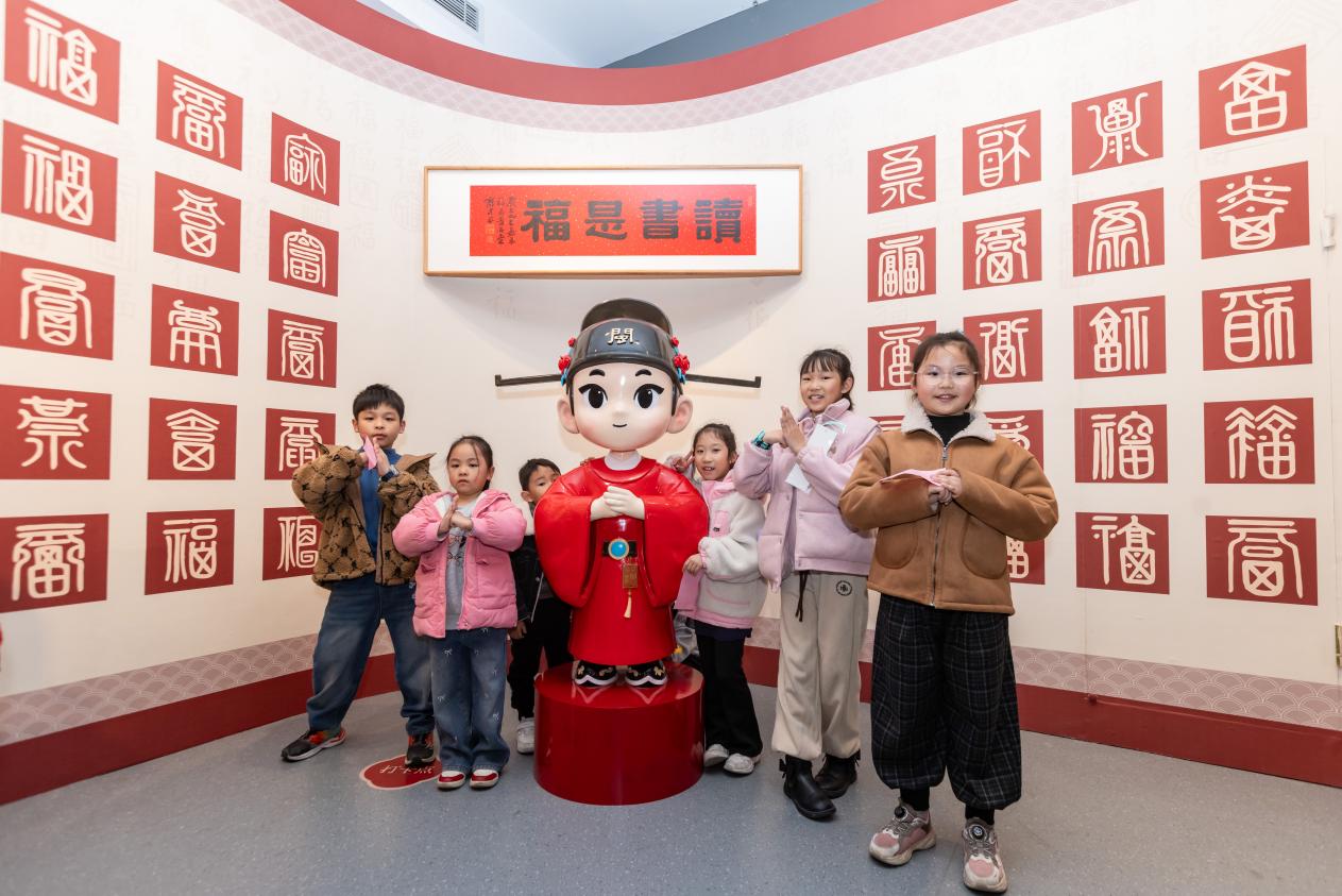 小读者们在“读书是福”主题墙前打卡合影