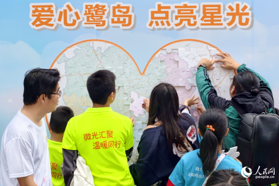 孩子们在志愿者帮助下完成爱心拼图。人民网记者 陈博摄
