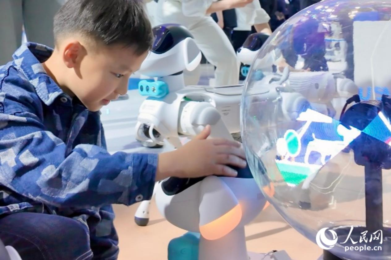 小朋友撫摸機器狗的“狗頭”。人民網 歐陽奕奕攝