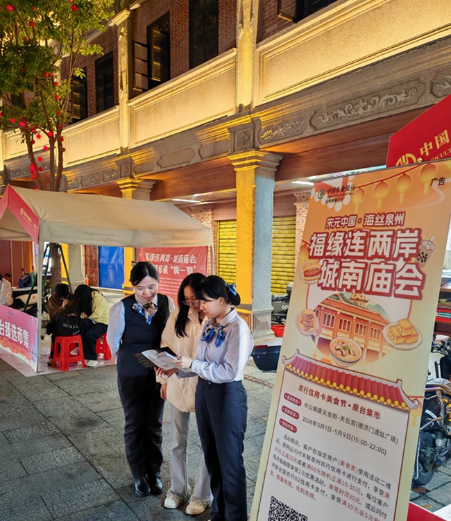 农行客户经理向游客介绍农行信用卡消费活动。
