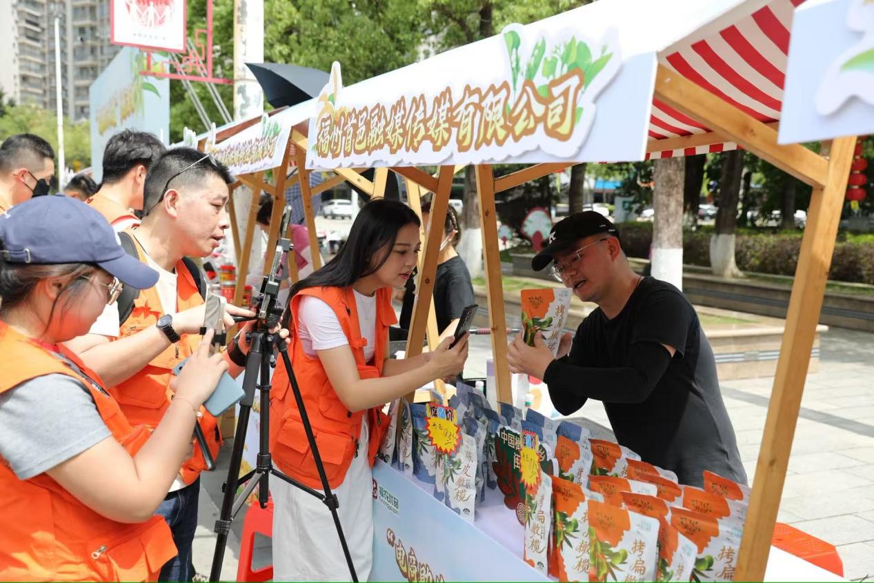 福建电商助农联盟代表在福州市闽侯县闽都民俗园农品市集，对着直播镜头推介闽侯特色农品。主办方供图