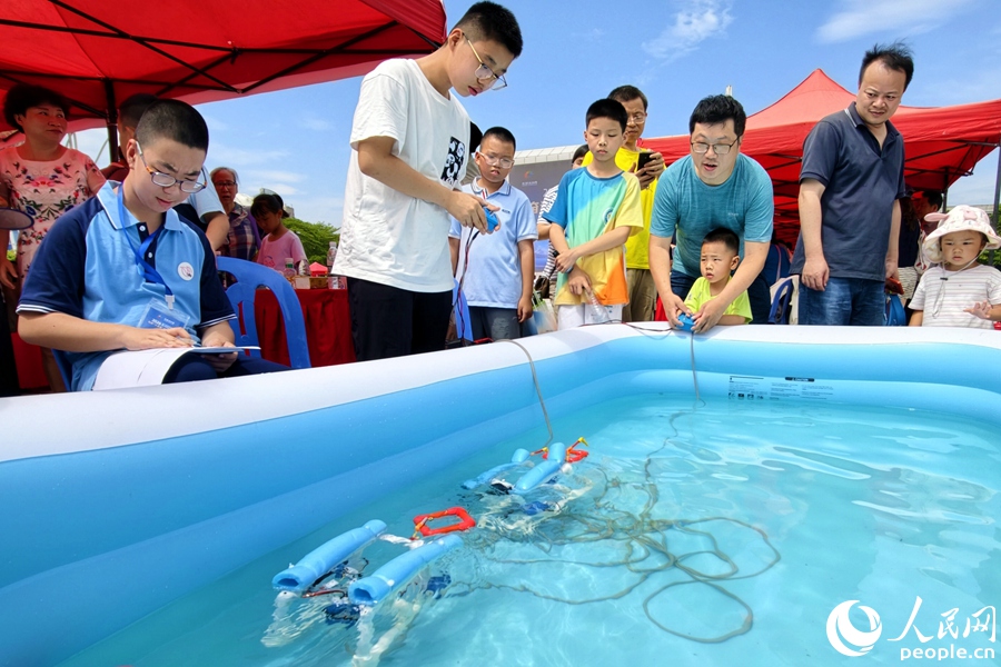 家長帶孩子體驗水中機器人操作。人民網記者 陳博攝