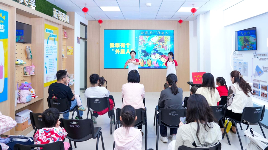 集美大學鳳凰花助飛成長營學生在四裡社區帶領親子家庭共讀繪本。思明區委社會工作部供圖
