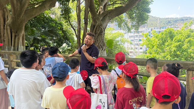 洪海樵向孩子們講解摩崖石刻上的文字及背后的故事。思明區融媒體中心供圖