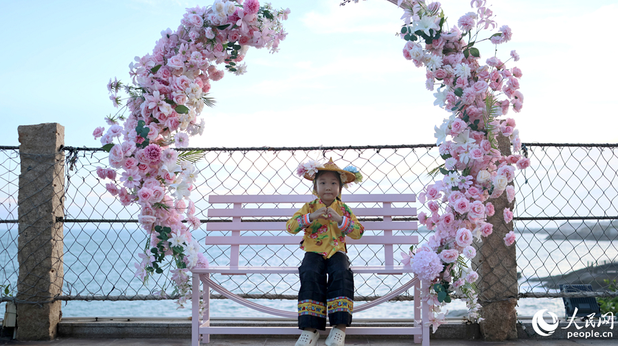 身着惠安女特色服饰的孩童在海边打卡，感受非遗魅力。人民网记者 李昌乾摄
