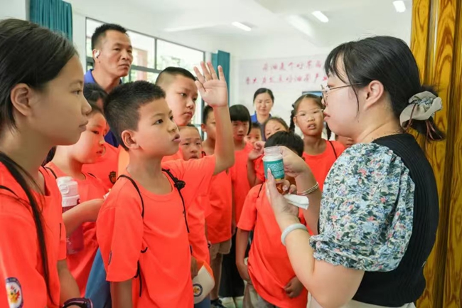 孩子們在白沙電氣化公共榨油中心近距離見証傳統榨油工藝與現代電力科技的碰撞