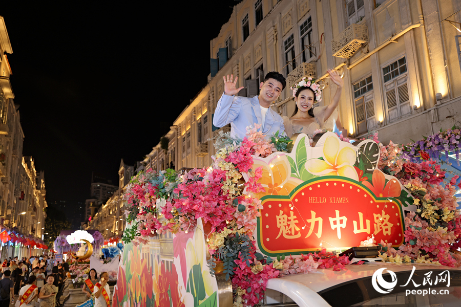 演员在花车上向市民游客挥手致意。人民网记者 陈博摄