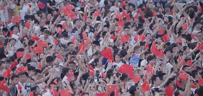 現場群眾激動地揮舞手中的國旗