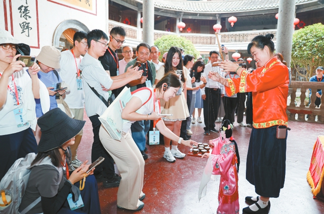 參訓記者在永定土樓景區振成樓內體驗非遺項目。 龍媒體記者 方晨穎 攝